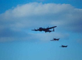 Photograph of the Battle of Britain Flight with the Lancaster leading the Hurricane and the Spitfire in single file formation