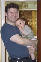 My son, David, standing in a doorway with baby Andrew in his arms (5th September 2004)